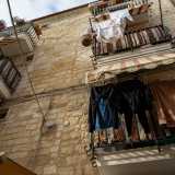 Questo tipo di gerle ha anche una funzione estremamente folkloristica, che noi abbiamo avuto la fortuna di ammirare passeggiando su strada delle Crociate. Qui vediamo infatti una signora affacciata al balcone che, alzando decisamente la voce...
